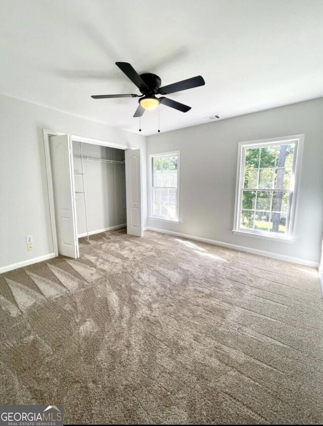 unfurnished bedroom featuring a closet, carpet flooring, visible vents, and baseboards