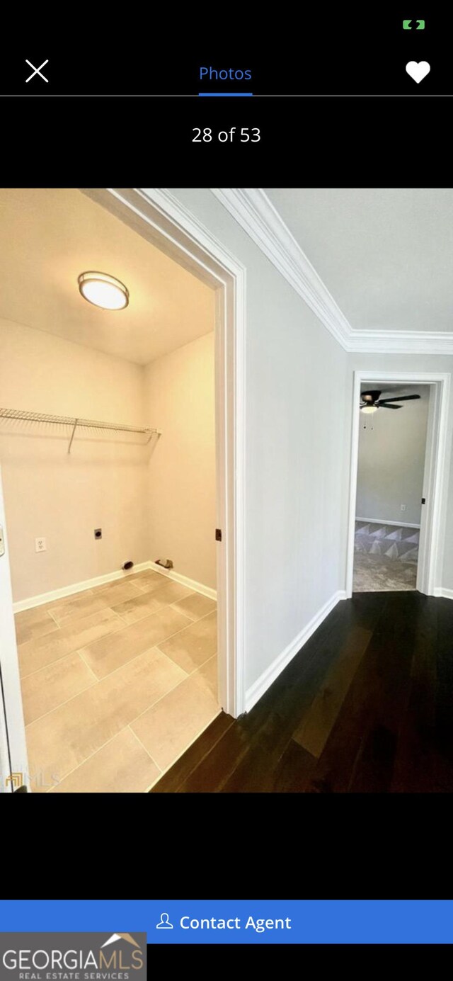 hallway with ornamental molding, baseboards, and wood finished floors