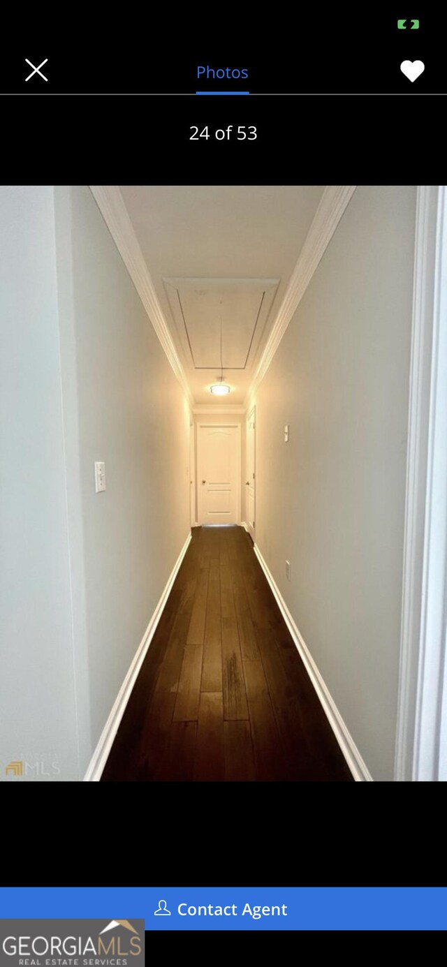 corridor featuring ornamental molding, attic access, baseboards, and wood finished floors