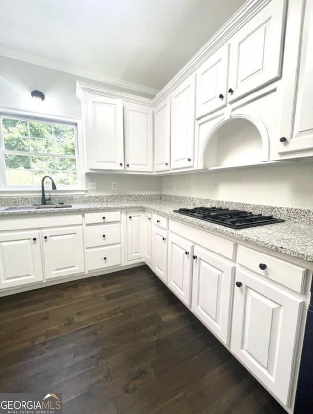 kitchen with crown molding, black gas stovetop, a sink, and white cabinets