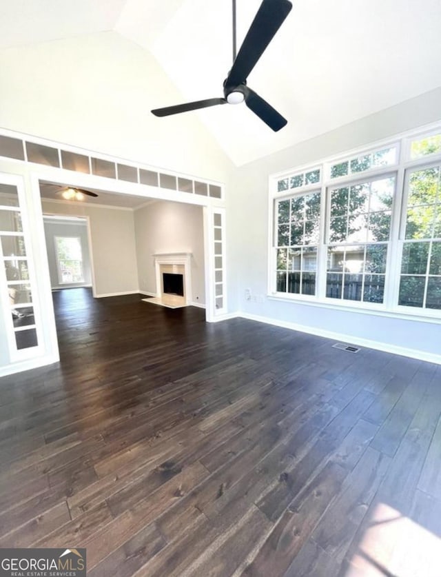 unfurnished living room with a ceiling fan, dark wood finished floors, visible vents, and a fireplace