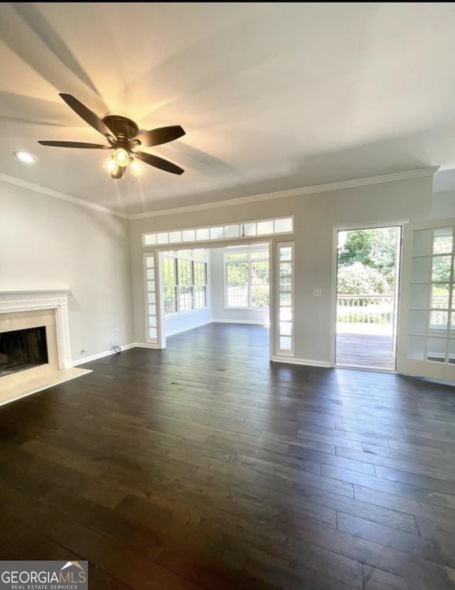 unfurnished living room featuring dark wood-style flooring, a fireplace, and crown molding