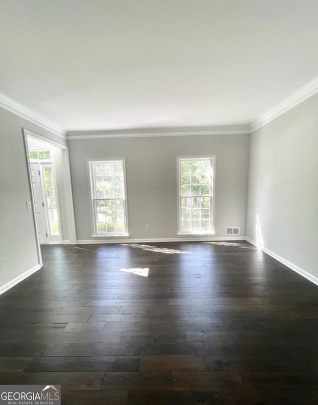 unfurnished room with a healthy amount of sunlight, baseboards, visible vents, and dark wood finished floors