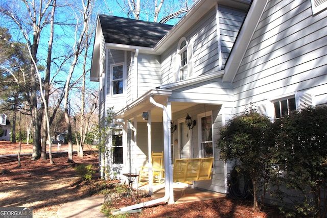 exterior space featuring covered porch and roof with shingles