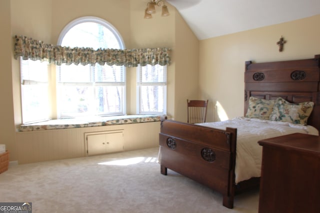 bedroom with vaulted ceiling and light colored carpet