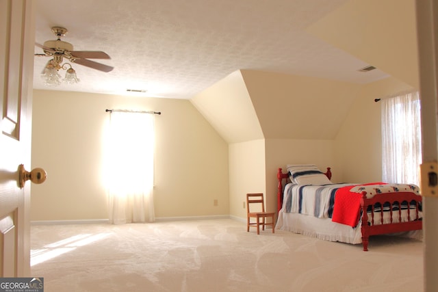 bedroom featuring light carpet, baseboards, vaulted ceiling, and a textured ceiling