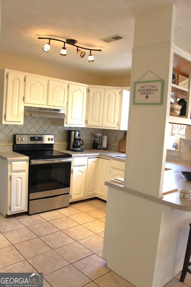 kitchen featuring under cabinet range hood, visible vents, white cabinets, light countertops, and stainless steel range with electric stovetop