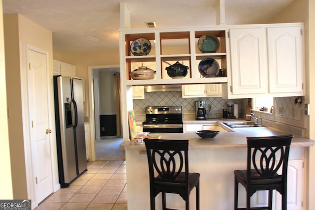 kitchen with open shelves, a kitchen bar, stainless steel appliances, and a peninsula