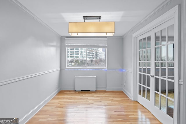 unfurnished room with baseboards, light wood-style floors, and crown molding