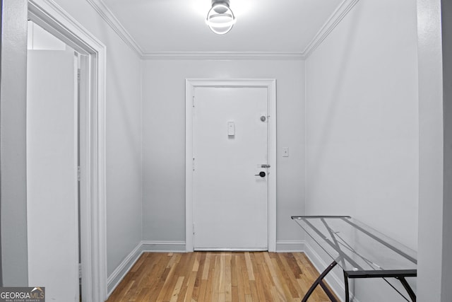 entryway with light wood-style floors, baseboards, and crown molding
