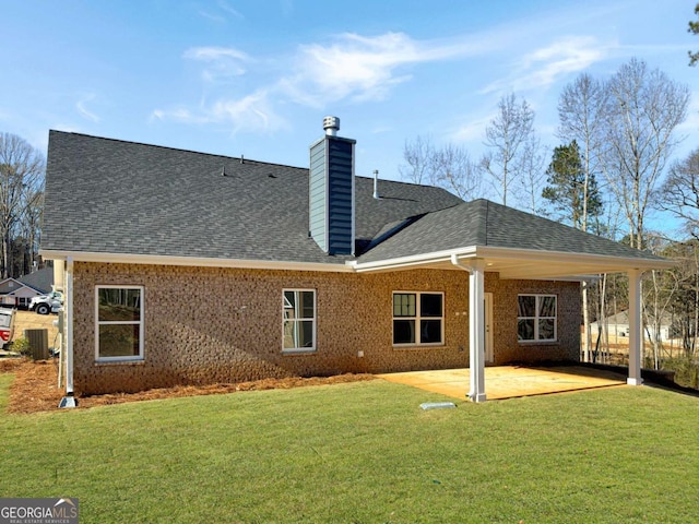 back of property featuring a patio area, a yard, brick siding, and roof with shingles