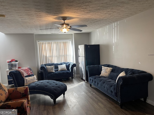 living area featuring a ceiling fan, dark wood finished floors, and a textured ceiling