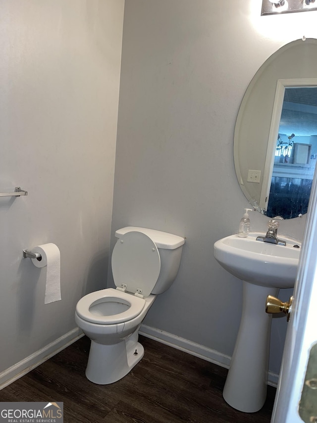 bathroom with baseboards, toilet, and wood finished floors