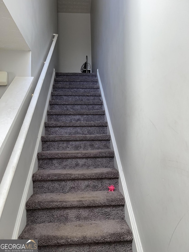 stairway featuring baseboards