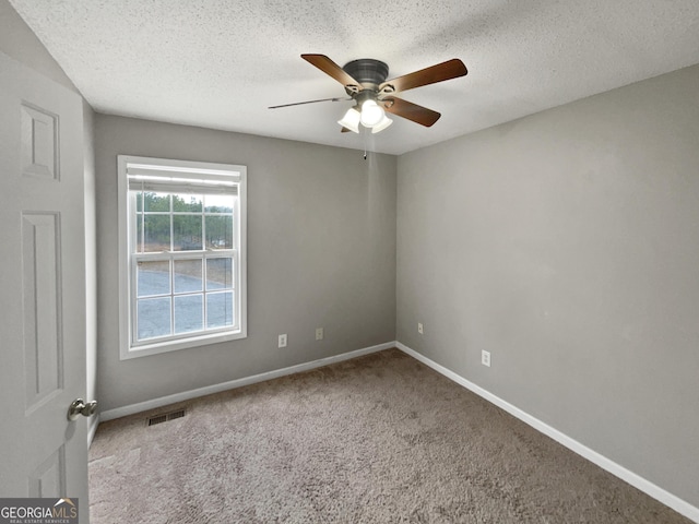 empty room featuring visible vents, baseboards, ceiling fan, carpet, and a textured ceiling