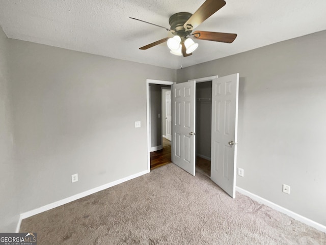 unfurnished bedroom featuring light carpet, a textured ceiling, and baseboards