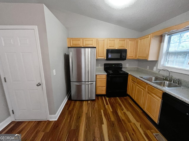 kitchen with light brown cabinets, black appliances, a sink, and light countertops