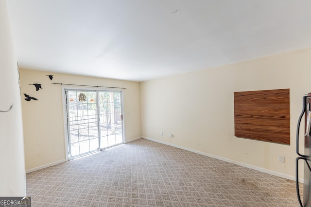 spare room with light carpet and baseboards