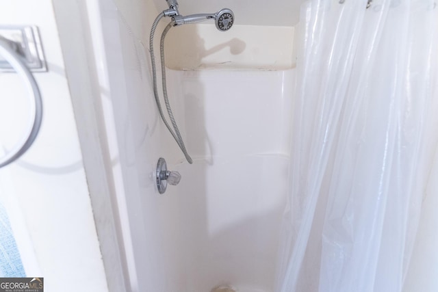 interior details featuring a shower with shower curtain