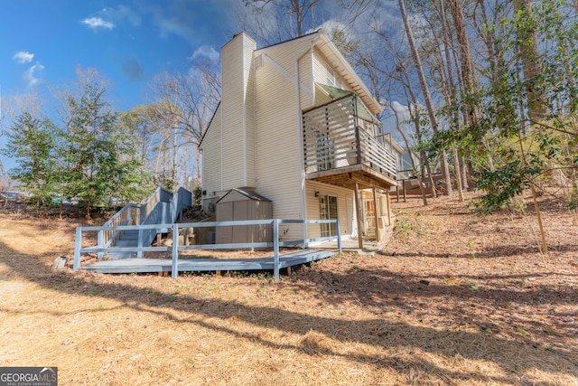 view of side of home featuring a chimney, a storage unit, and a deck