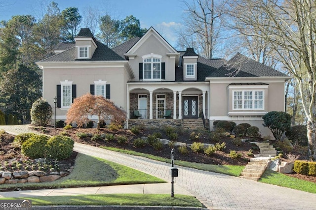 view of front of property featuring stairs, a porch, and stucco siding