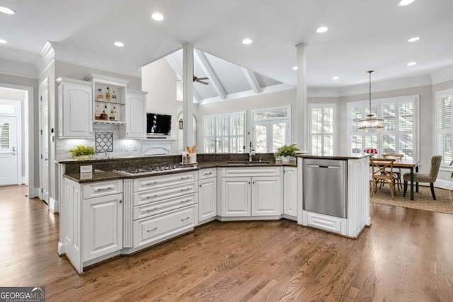 kitchen featuring dark stone counters, stainless steel appliances, white cabinetry, open shelves, and a sink