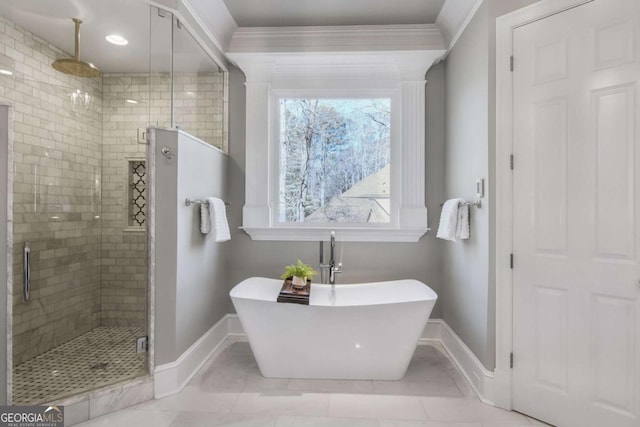 full bathroom with a freestanding bath, ornamental molding, a shower stall, and baseboards