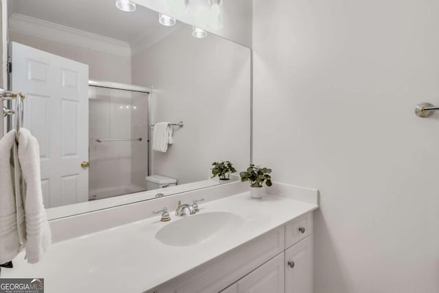 full bath with ornamental molding, a shower with shower door, vanity, and toilet