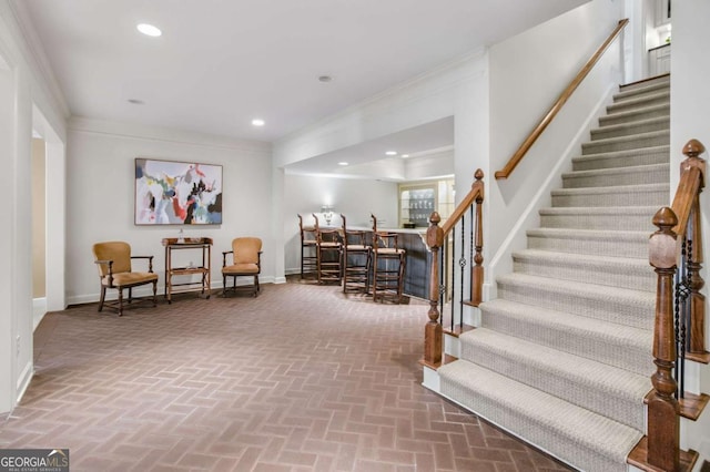 living area featuring brick floor, recessed lighting, ornamental molding, a bar, and baseboards