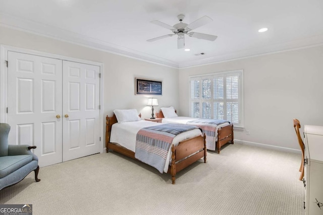 bedroom featuring ornamental molding, a closet, light carpet, and baseboards