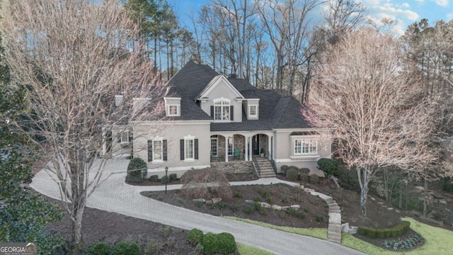 view of front of home featuring driveway, a shingled roof, and stucco siding