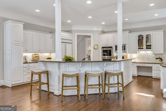 kitchen featuring glass insert cabinets, a center island, white cabinetry, and dark wood finished floors