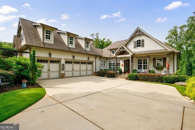 craftsman house featuring a garage, concrete driveway, covered porch, and a shingled roof