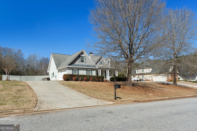 view of front of house with a front yard, concrete driveway, and fence