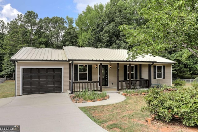 ranch-style home featuring metal roof, driveway, a porch, and an attached garage