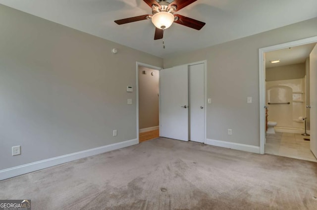 unfurnished bedroom with baseboards, a closet, ensuite bath, and light colored carpet