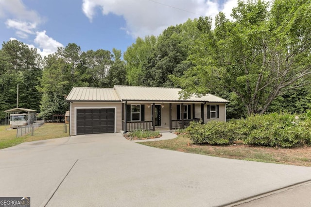 single story home featuring covered porch, driveway, metal roof, and a garage