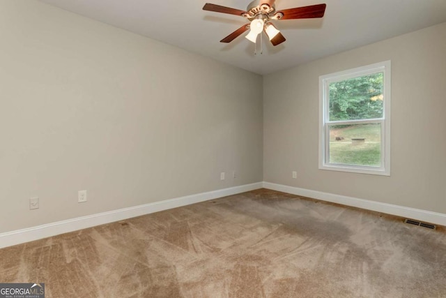 empty room featuring a ceiling fan, carpet, visible vents, and baseboards