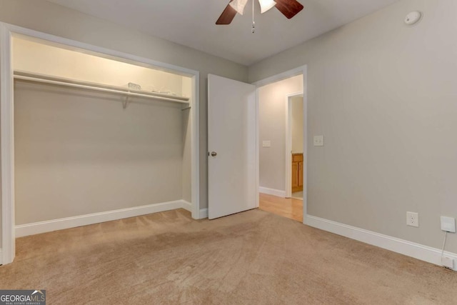 unfurnished bedroom with light carpet, ceiling fan, baseboards, and a closet