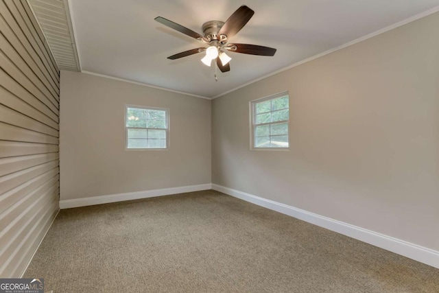 carpeted empty room with a healthy amount of sunlight, baseboards, and ornamental molding