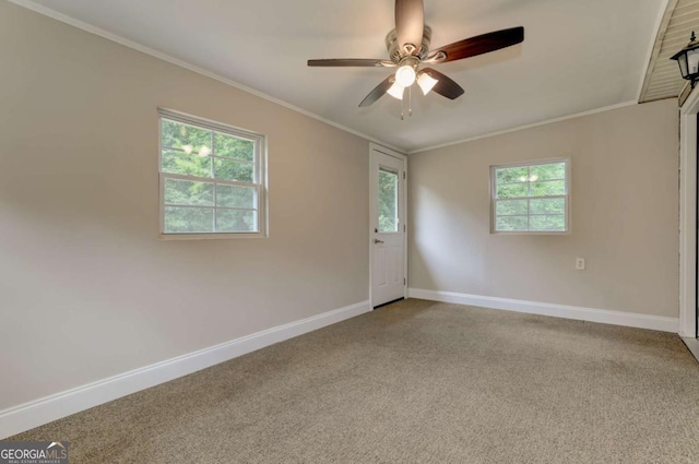 carpeted empty room with baseboards, ceiling fan, and crown molding