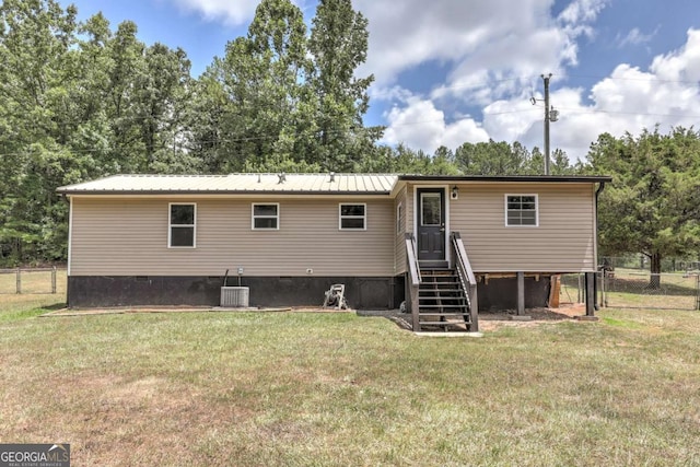 back of house with metal roof, central AC, fence, crawl space, and a lawn