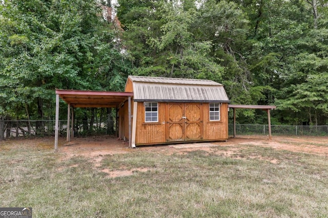 view of shed featuring a carport, fence, and driveway