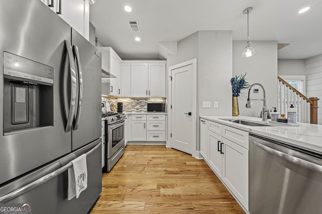 kitchen with white cabinetry, visible vents, appliances with stainless steel finishes, and light stone counters