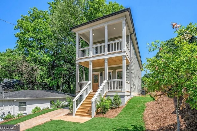 view of front of property with a porch, stairs, a balcony, and central AC unit