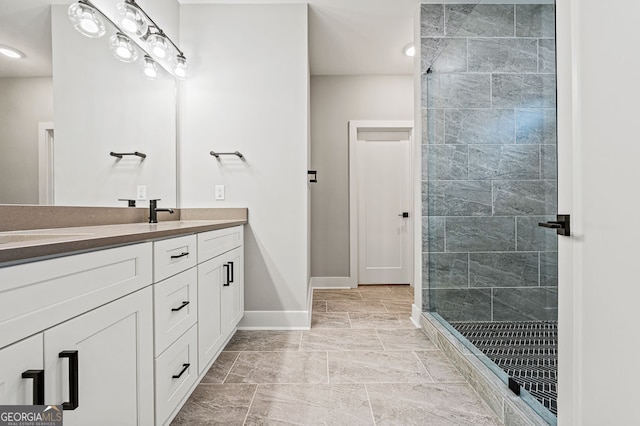 full bathroom featuring a stall shower, vanity, and baseboards