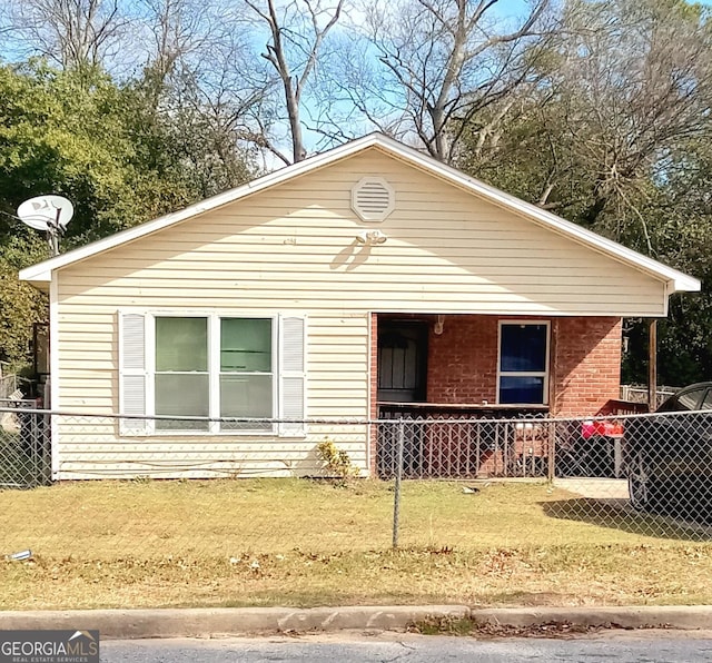 view of front of house featuring brick siding, a front yard, and fence private yard