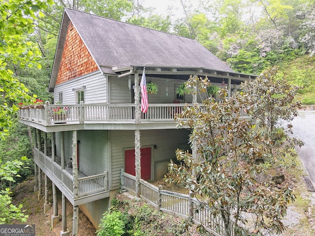 view of front of property featuring a deck and roof with shingles