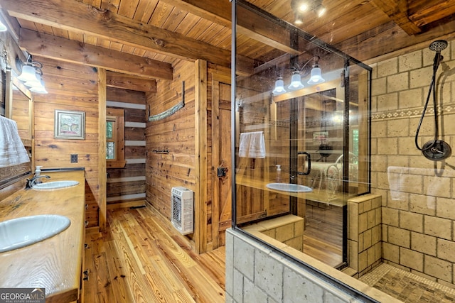 full bathroom with a stall shower, a sink, wood ceiling, and wooden walls