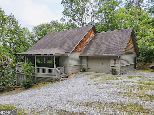 view of front of home with a garage, roof with shingles, driveway, and a porch